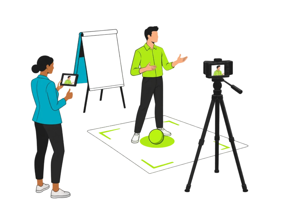 Mitarbeiter präsentiert vor einer Kamera auf Stativ, eine Trainerin verfolgt die Aufnahme auf dem Tablet