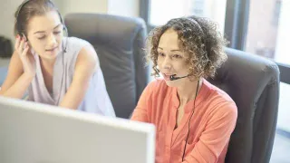 NEVEREST - Lehrlingsförderung - zwei Frauen vor Monitor mit Headset