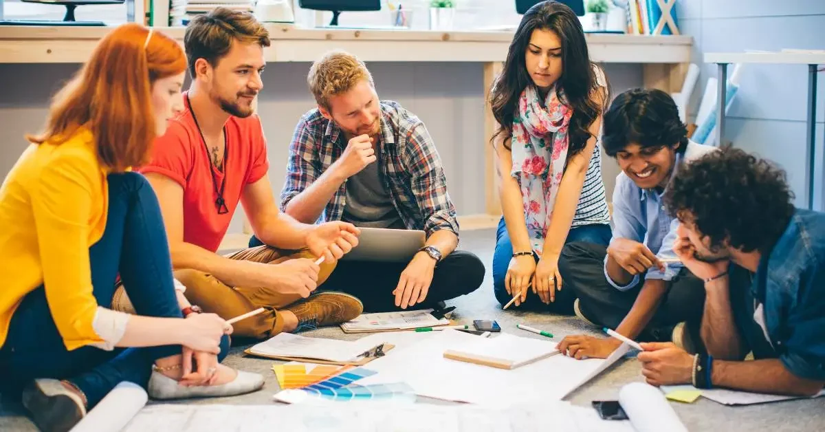 NEVEREST Brainstorming Gruppe sitzt am Boden und arbeitet Ideen aus