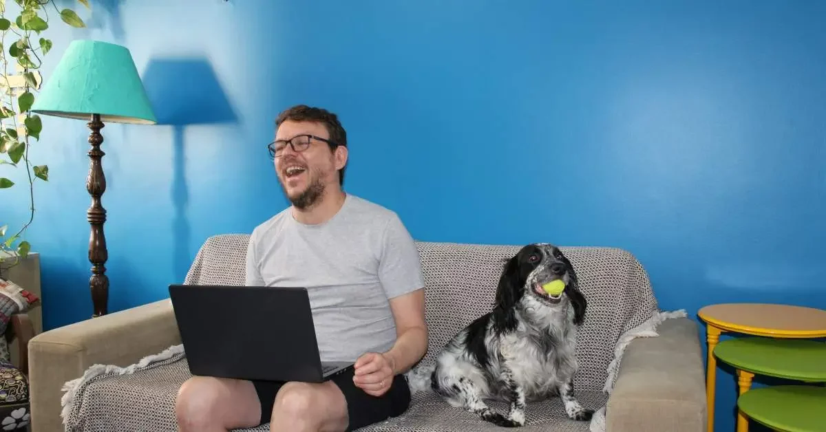 NEVEREST Home Office Mann sitzt mit Hund auf der couch 