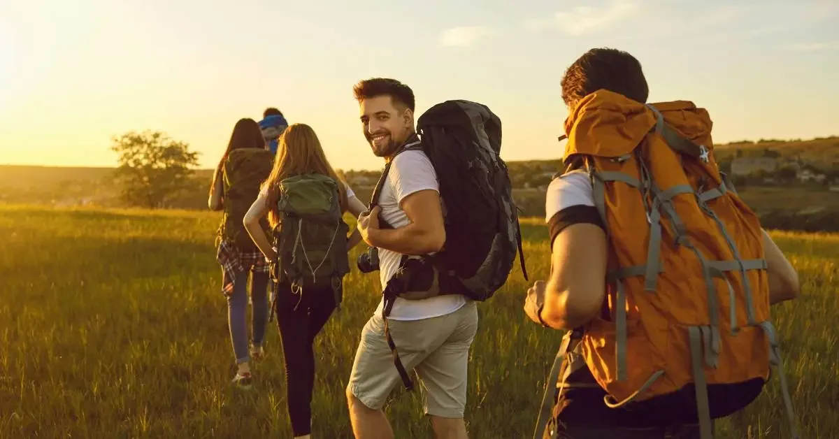 NEVEREST Blog Wanderführer Ausbildung Gruppe von Menschen wandert, ein Mann dreht sich um und lächelt in die Kamera