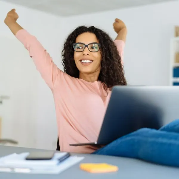 NEVEREST Resilienz Trainerausbildung Frau streckt sich selbstbewusst am Arbeitsplatz