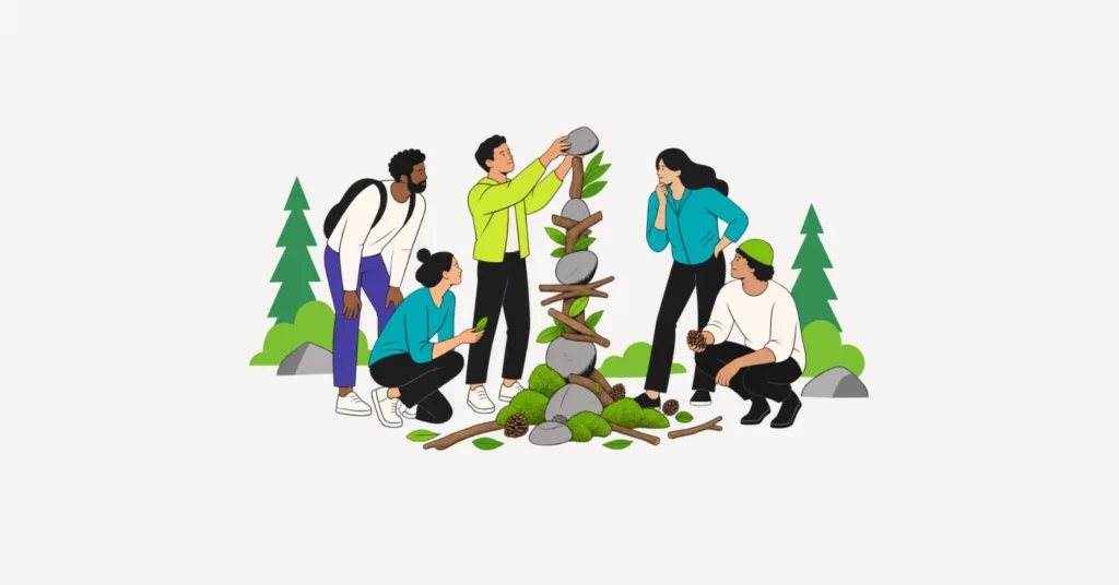 Gruppe baut im Wald aus Steinen, Ästen und Moos gemeinsam ein Totem